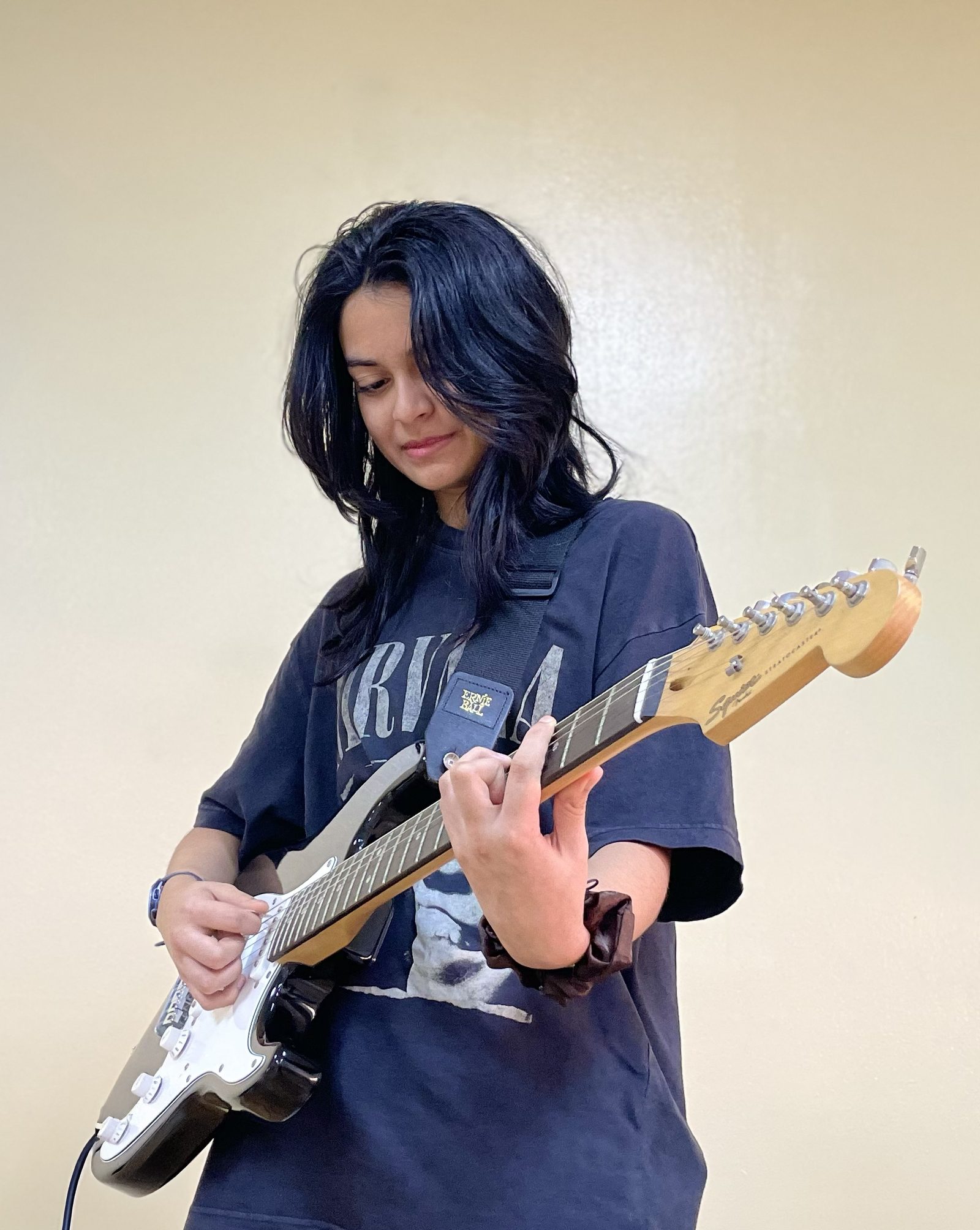 A young girl playing an electric guitar