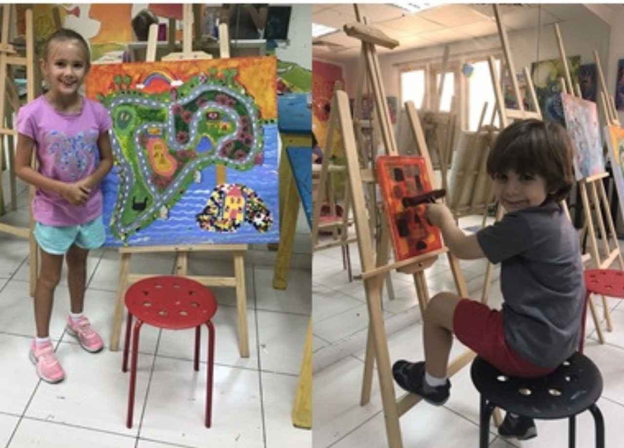 2 children painting on easels