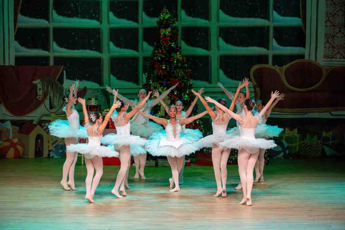 Female ballerinas surrounding one ballet dancer