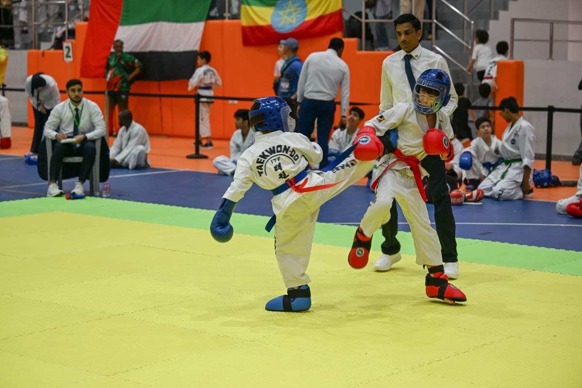 two children in taekwondo fight on mat
