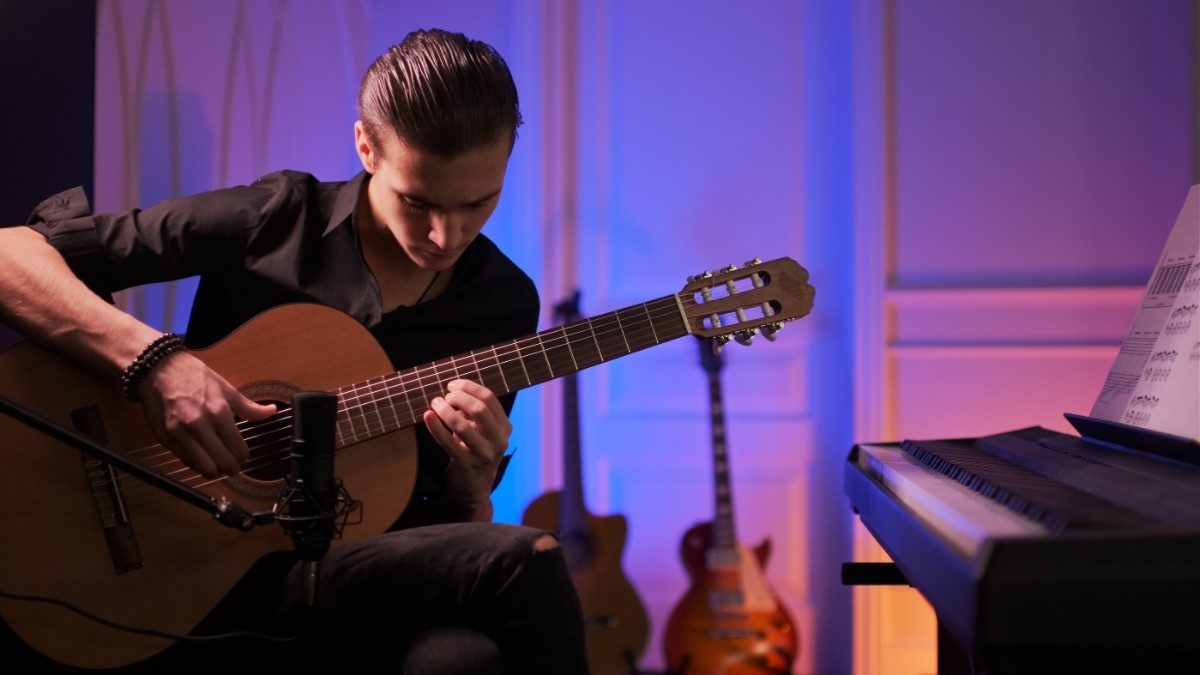 man playing guitar while seated