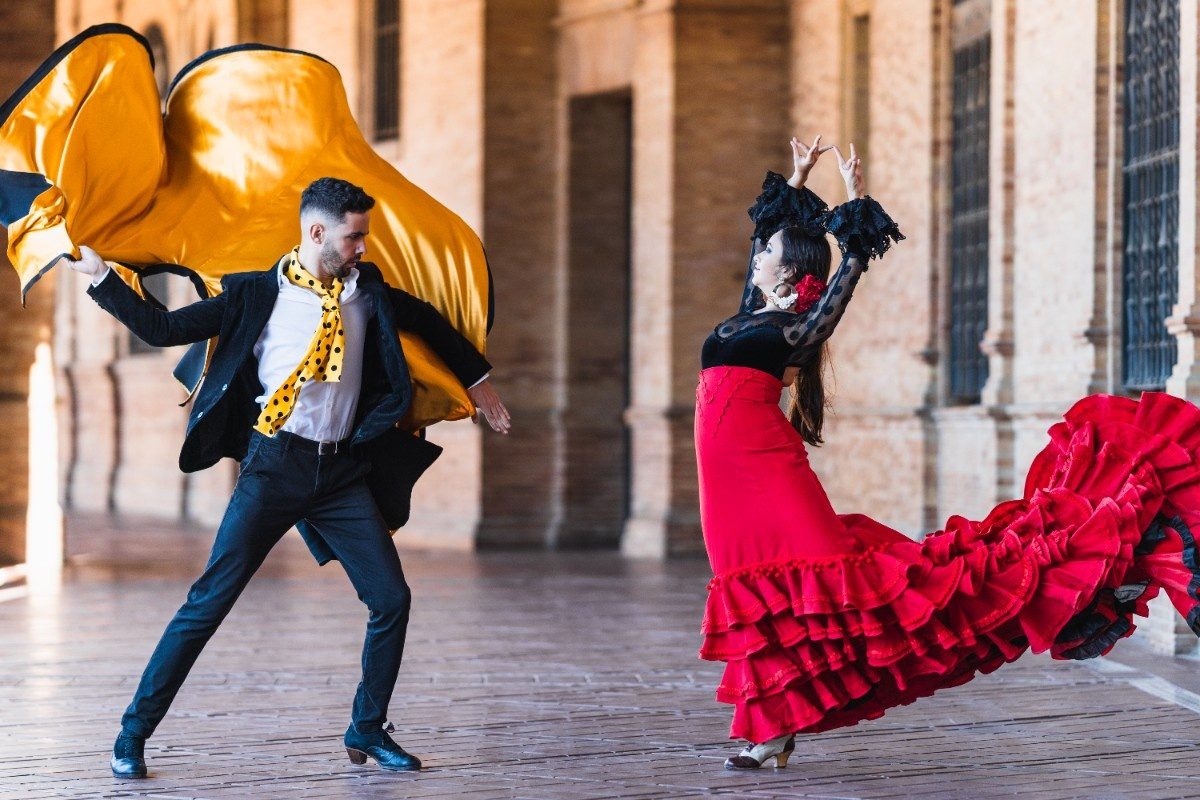 Man with a cloth dancing falmenco with a woman outdoors