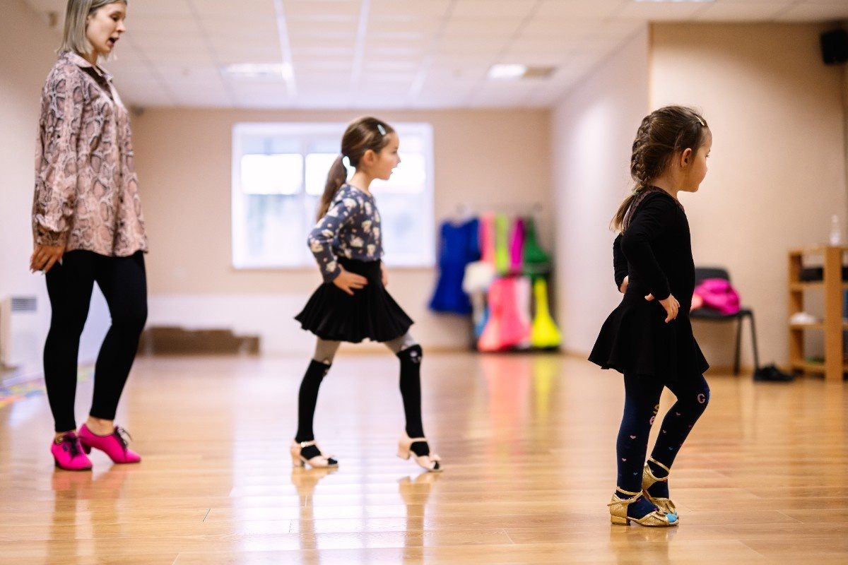 Young Girls Learning Dance Moves in Classroom with Instructor