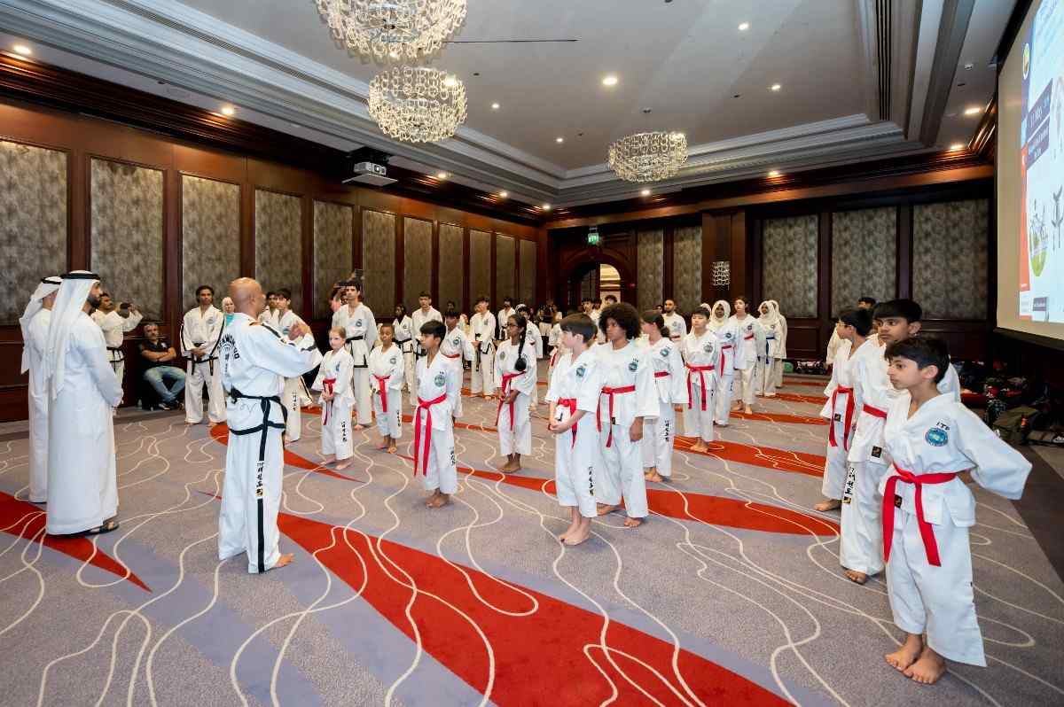 chldren in straight lines as they face their taekwondo instructor