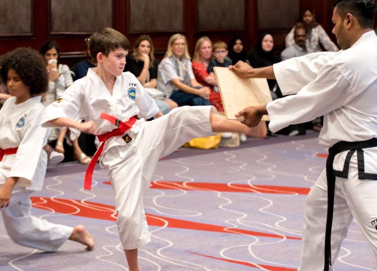 taekwondo student breaking wooden board with a kick