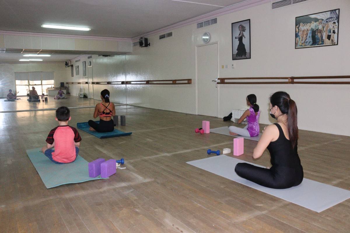 four people sitting in yoga poses