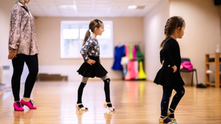Young Girls Learning Dance Moves in Classroom with Instructor