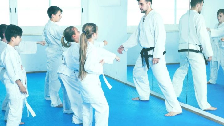 Kids i martial arts class wearing martial arts kit