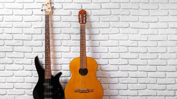 Set of guitars on the floor against white brick wall