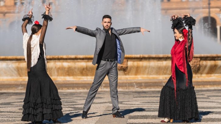 Three people dancing flamenco in a traditional square
