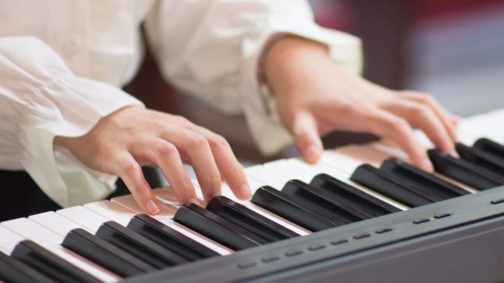 hands playing a piano