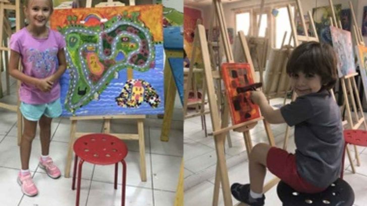 2 children painting on easels