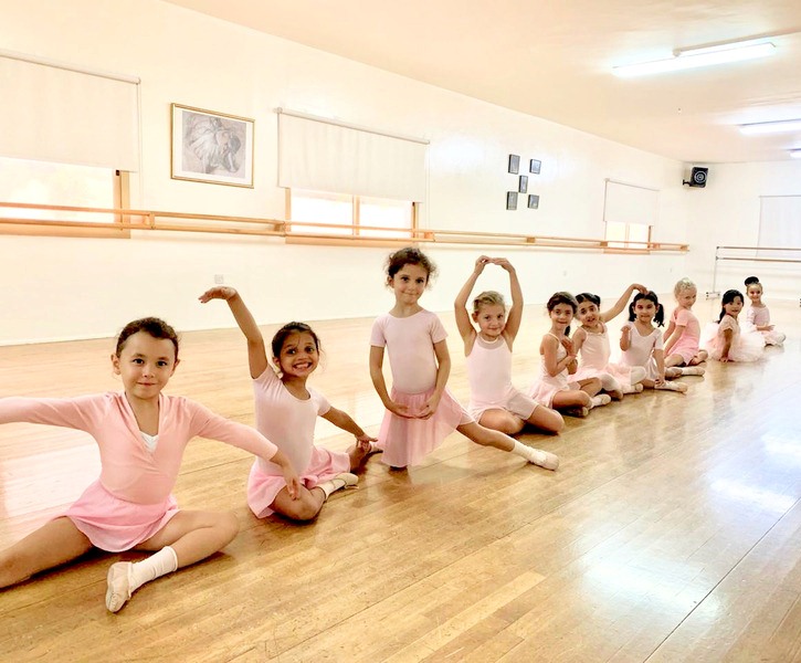 The youngest ballet class sitting together on the studio floor